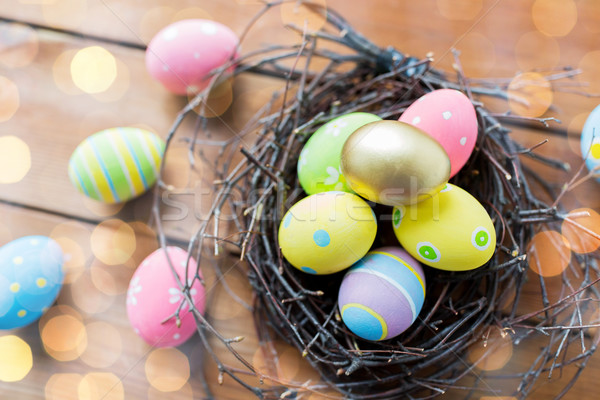 close up of colored easter eggs in nest on wood Stock photo © dolgachov