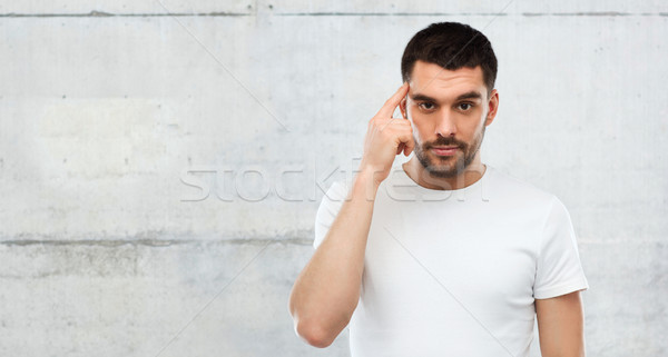 man with finger at temple over gray wall Stock photo © dolgachov