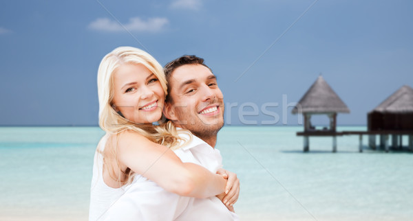 happy couple having fun over beach with bungalow Stock photo © dolgachov