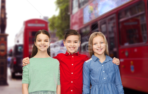 happy boy and girls hugging over london city Stock photo © dolgachov