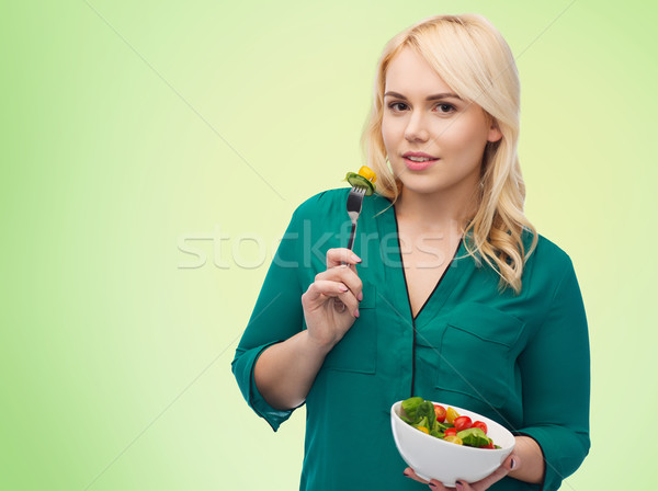 smiling young woman eating vegetable salad Stock photo © dolgachov
