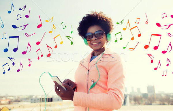 happy young woman with smartphone and headphones Stock photo © dolgachov