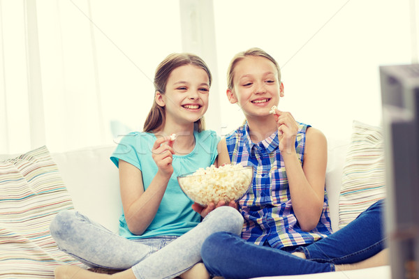 Szczęśliwy dziewcząt popcorn oglądania telewizja domu Zdjęcia stock © dolgachov