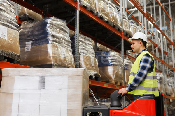 man on forklift loading cargo at warehouse Stock photo © dolgachov