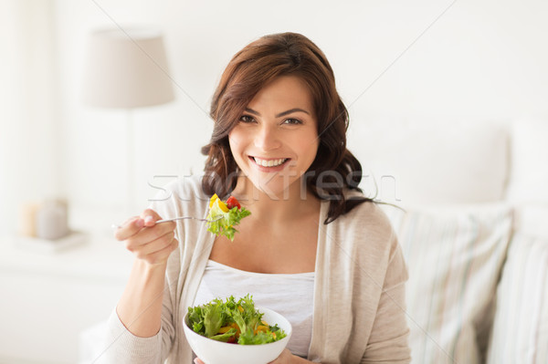 smiling young woman eating salad at home Stock photo © dolgachov