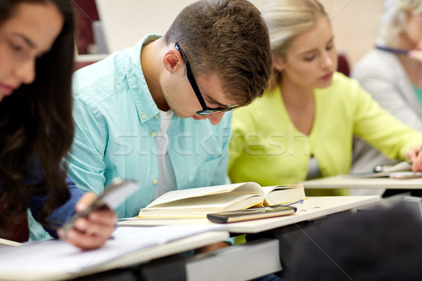 male student in glasses reading book at lecture Stock photo © dolgachov