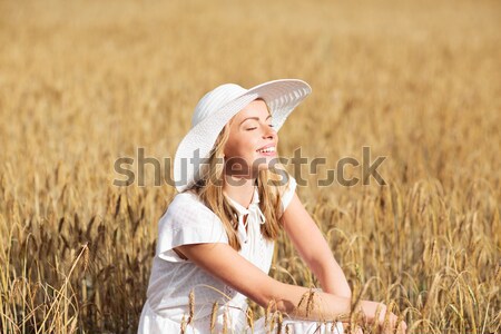 happy young woman in sun hat on cereal field Stock photo © dolgachov