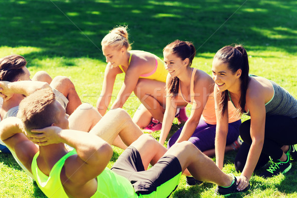 group of friends or sportsmen exercising outdoors Stock photo © dolgachov