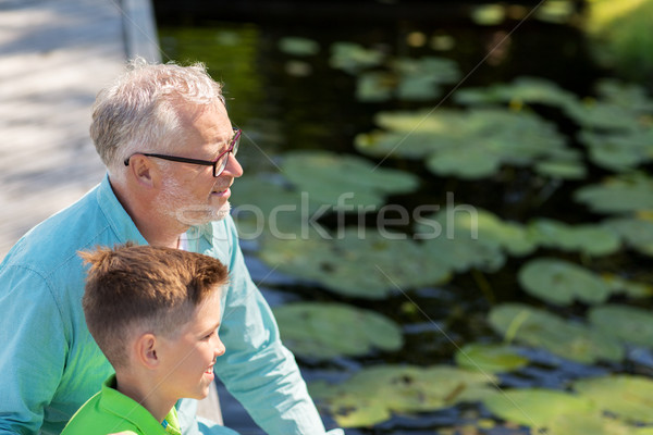 Dziadek wnuk posiedzenia rzeki rodziny pokolenie Zdjęcia stock © dolgachov