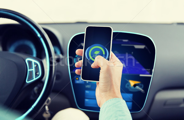 man driving car and setting eco mode on smartphone Stock photo © dolgachov