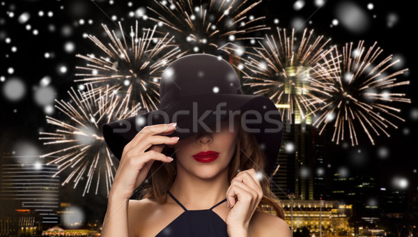 beautiful woman in black hat over night firework Stock photo © dolgachov