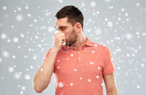 sick man with paper wipe blowing nose over snow Stock photo © dolgachov