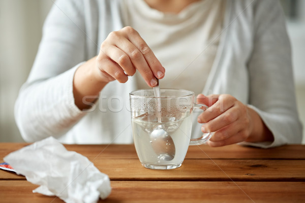 woman stirring medication in cup with spoon Stock photo © dolgachov