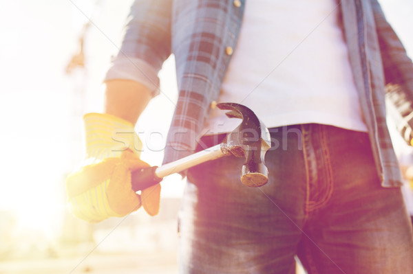 Stock photo: close up of builder hand in glove holding hammer