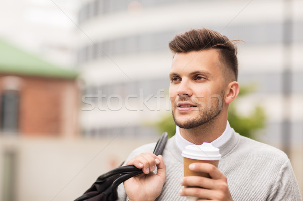 young man with bag drinking coffee in city Stock photo © dolgachov