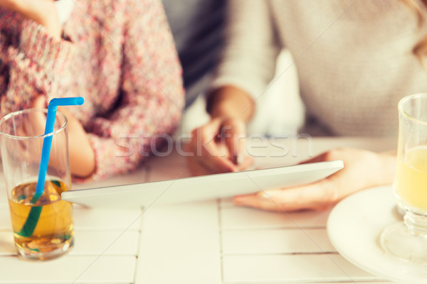 Stock photo: close up of family with tablet pc at restaurant