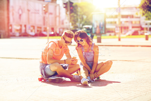 couple with skateboards and smartphone in city Stock photo © dolgachov
