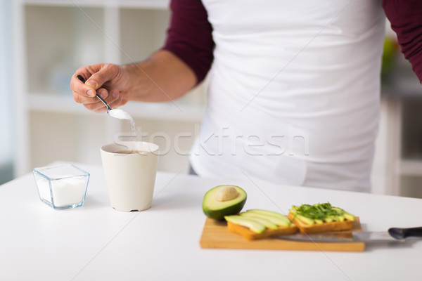 man having breakfast and adding sugar to coffee Stock photo © dolgachov