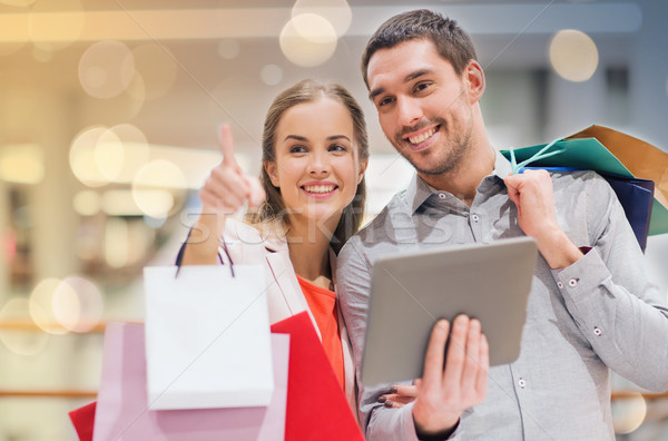 couple with tablet pc and shopping bags in mall Stock photo © dolgachov
