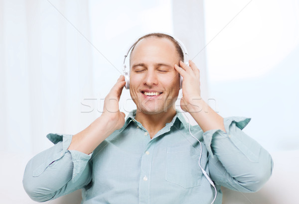smiling man with headphones listening to music Stock photo © dolgachov
