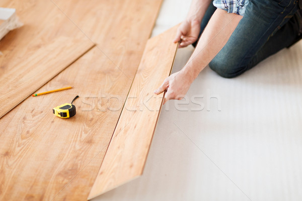 close up of male hands intalling wood flooring Stock photo © dolgachov