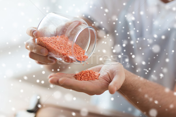 close up of man emptying jar with red lentils Stock photo © dolgachov