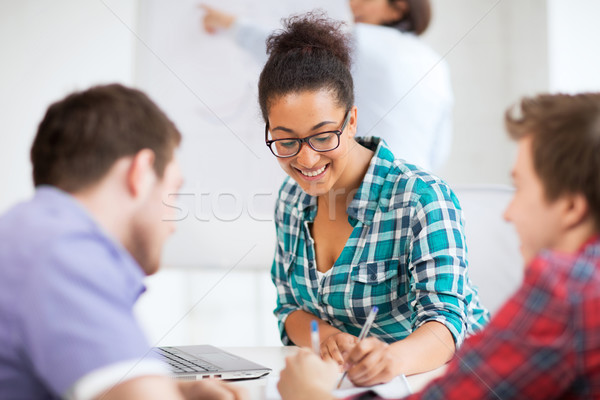 african student writing something in notebook Stock photo © dolgachov