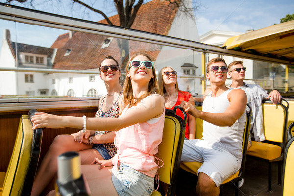 group of smiling friends traveling by tour bus Stock photo © dolgachov