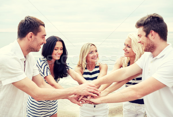 smiling friends putting hands on top of each other Stock photo © dolgachov