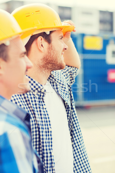 Stock photo: group of smiling builders in hardhats outdoors