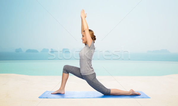 happy woman making yoga in low lunge on mat Stock photo © dolgachov