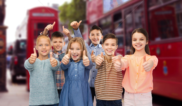 happy children showing thumbs up over london city Stock photo © dolgachov