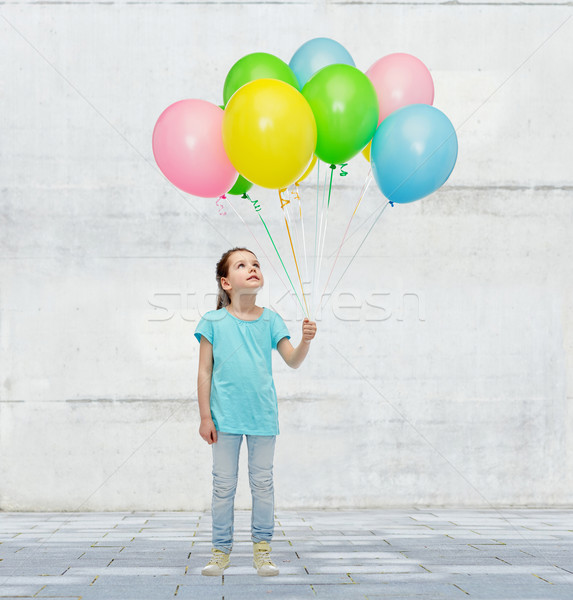 girl looking up with bunch of helium balloons Stock photo © dolgachov