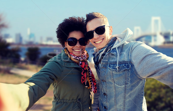 happy teenage couple taking selfie in tokyo Stock photo © dolgachov