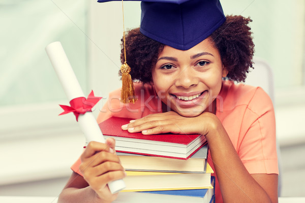 Gelukkig afrikaanse vrijgezel meisje boeken diploma Stockfoto © dolgachov