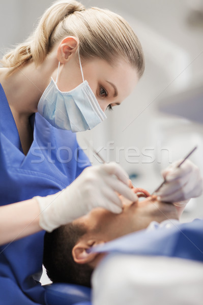 Femeie dentist in sus masculin pacient dinţi Imagine de stoc © dolgachov