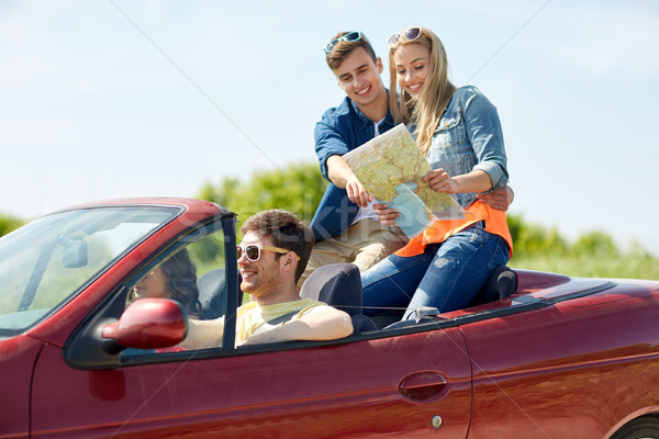 happy friends with map driving in cabriolet car Stock photo © dolgachov