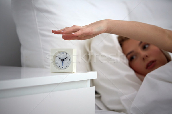 close up of woman with alarm clock in bed at home Stock photo © dolgachov