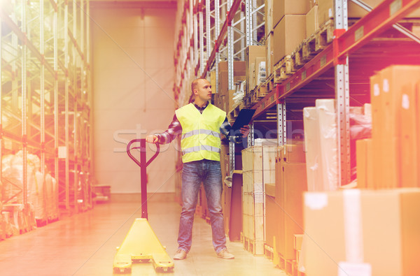 man with loader and clipboard at warehouse Stock photo © dolgachov