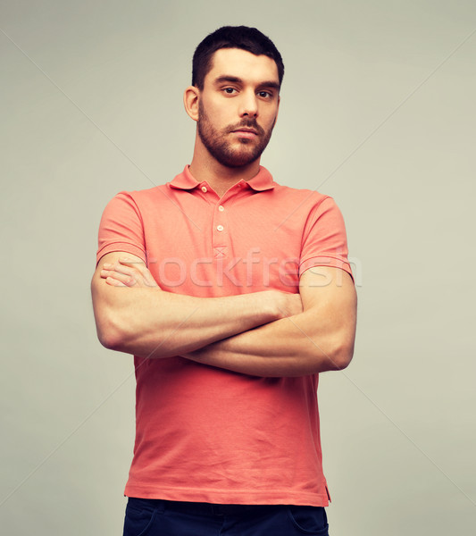 Stock photo: young man with crossed arms over gray background