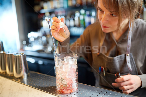 bartender adding essence to cocktail glass at bar Stock photo © dolgachov