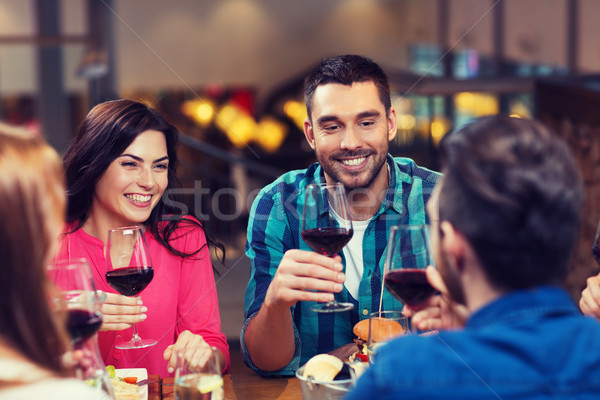 Stock photo: friends dining and drinking wine at restaurant