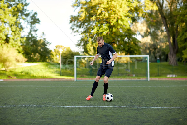 Stock photo: soccer player playing with ball on football field