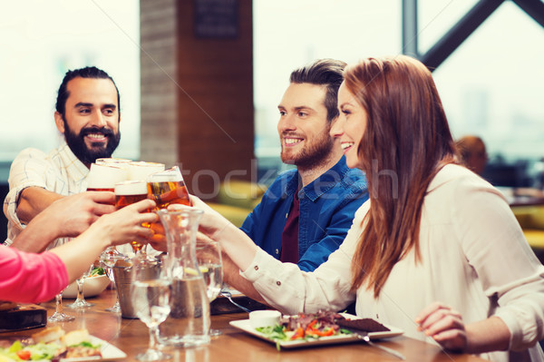 friends dining and drinking beer at restaurant Stock photo © dolgachov