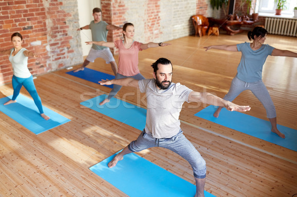 Grup de oameni yoga războinic pune studio fitness Imagine de stoc © dolgachov