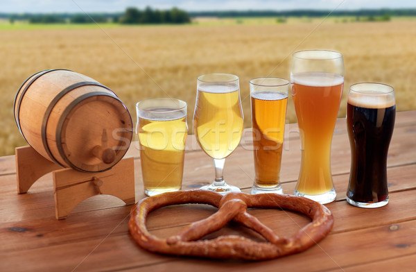 beer glasses, barrel and pretzel over cereal field Stock photo © dolgachov
