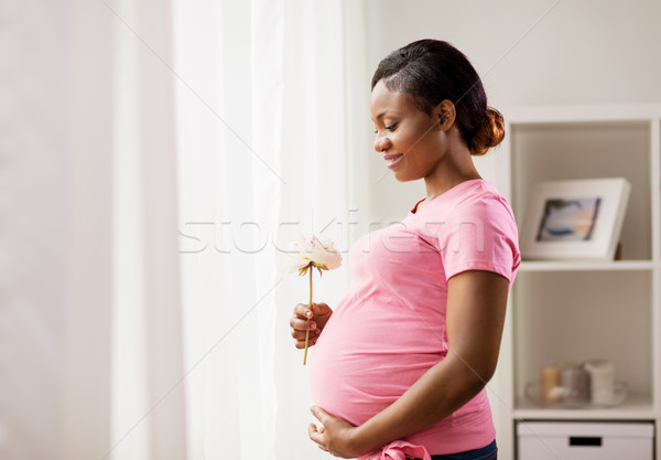 happy african american pregnant woman with flower Stock photo © dolgachov