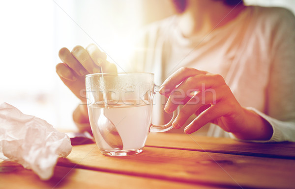 woman stirring medication in cup with spoon Stock photo © dolgachov