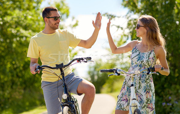 happy couple with bicycles making high five Stock photo © dolgachov