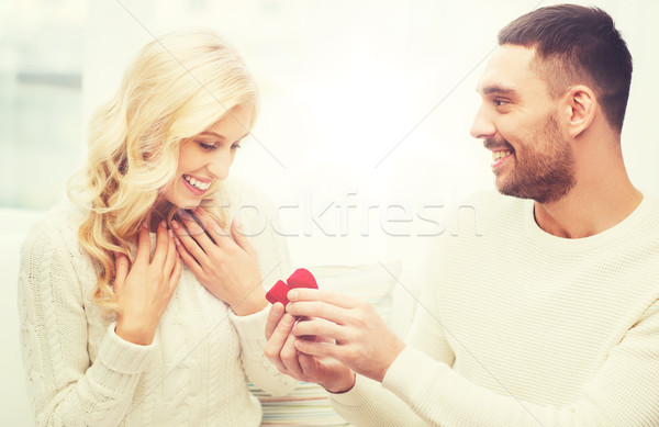 happy man giving engagement ring to woman at home Stock photo © dolgachov